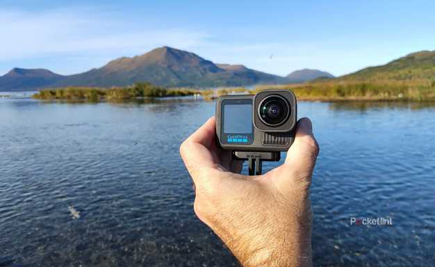 A person holding a GoProHERO13 Black in the Alaskan wilderness. 