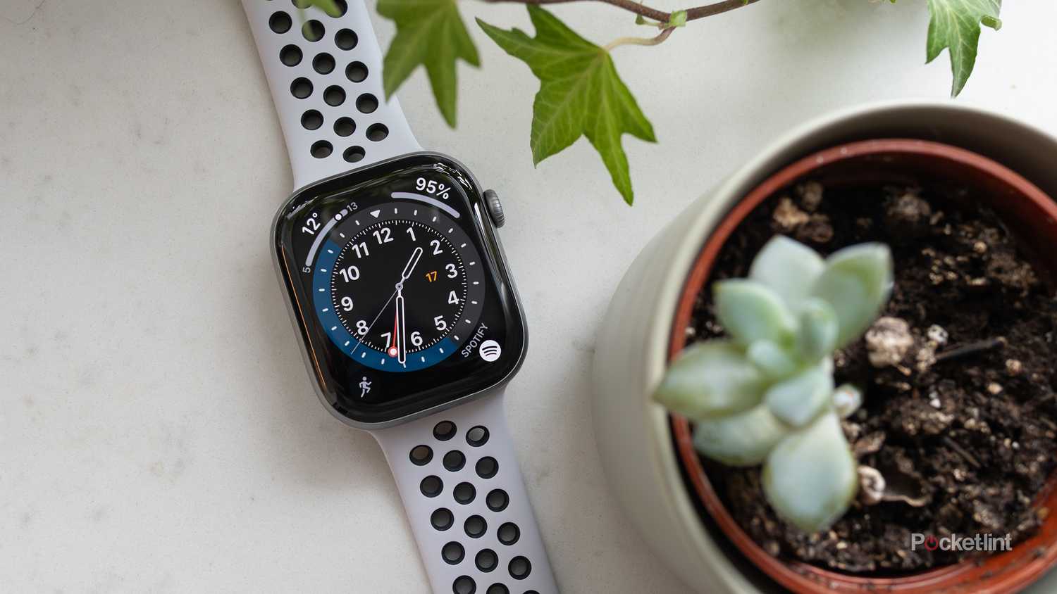 The Apple Watch Series 11 sitting on a counter beside a plant