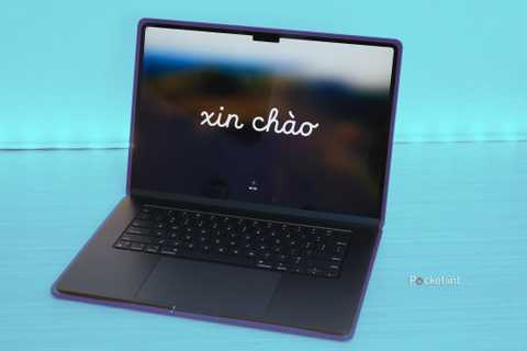 A M3 MacBook Air open on a table, over a blue background.