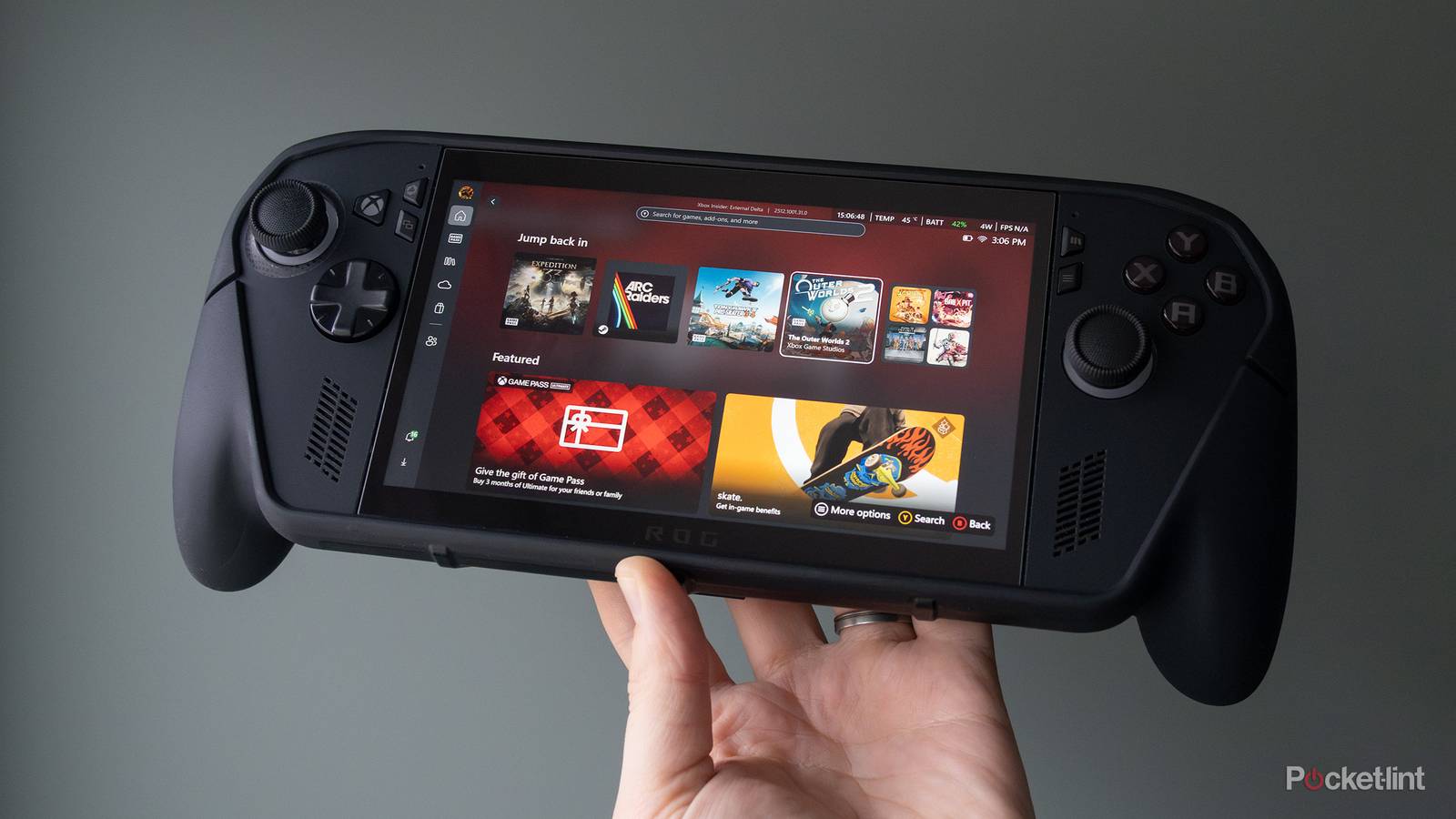 The ROG Xbox Ally X Killswitch case being held in front of a green wall 