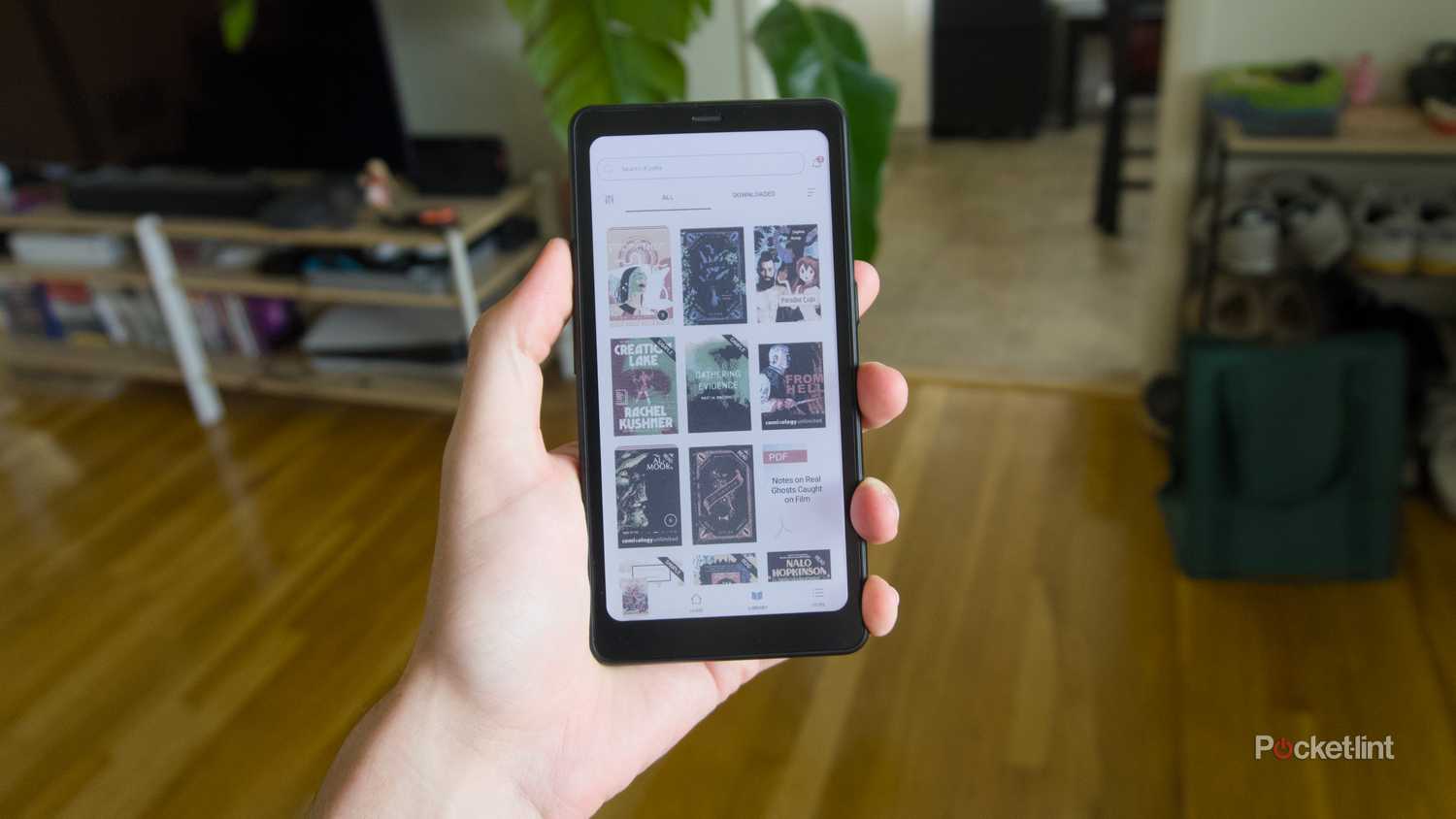 A hand holding a Palma 2 Pro displaying the Kindle app.