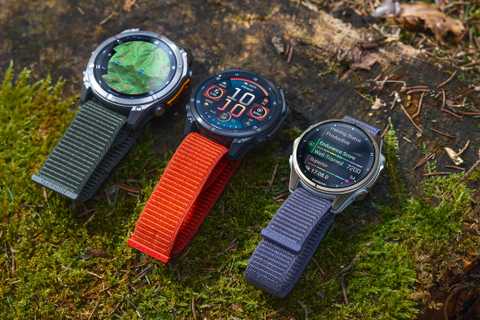 Three Garmin fenix 8 watches are lined up on a mossy ground. 