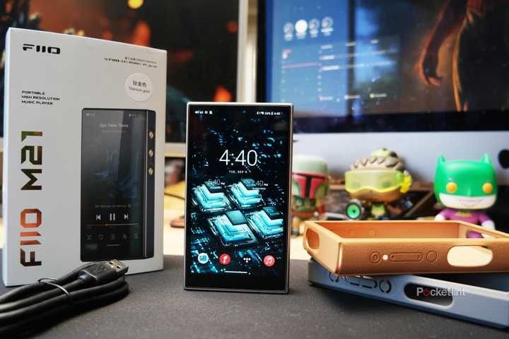 FiiO M21 on a desk with its packaging contents displayed around it.