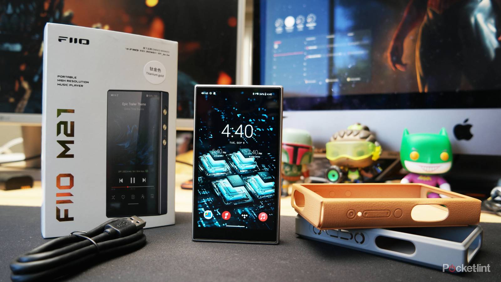 FiiO M21 on a desk with its packaging contents displayed around it.