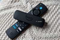 Fire TV Stick and Fire TV remote on knit pillow.