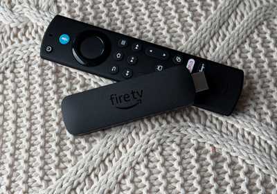 Fire TV Stick and remote on knitted pillow.