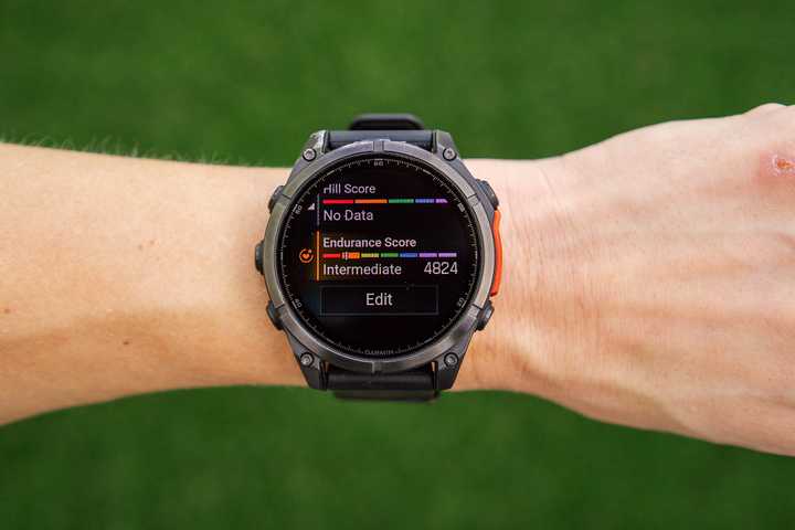 A hand holds a Garmin Fenix 8 with the Endurance Score on the display. 