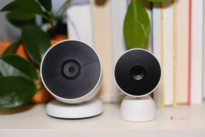 The Google Nest Cam Battery sits next to the Google Nest Cam Wired on a bookshelf