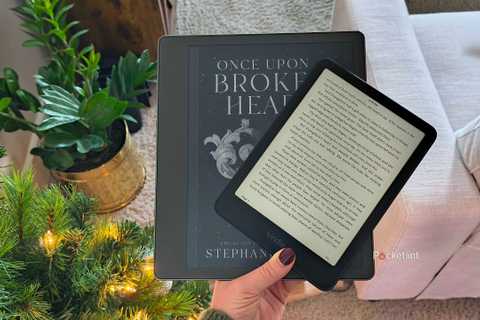 Two Kindles in hand. 