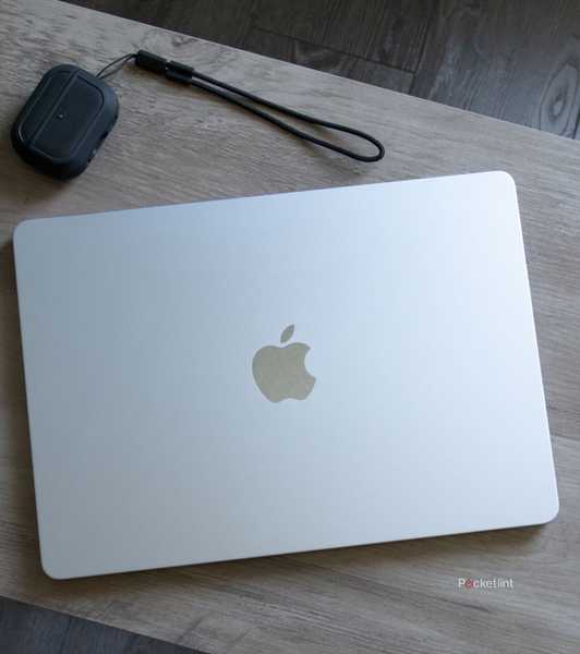 An M4 MacBook Air on a desk with earbuds.