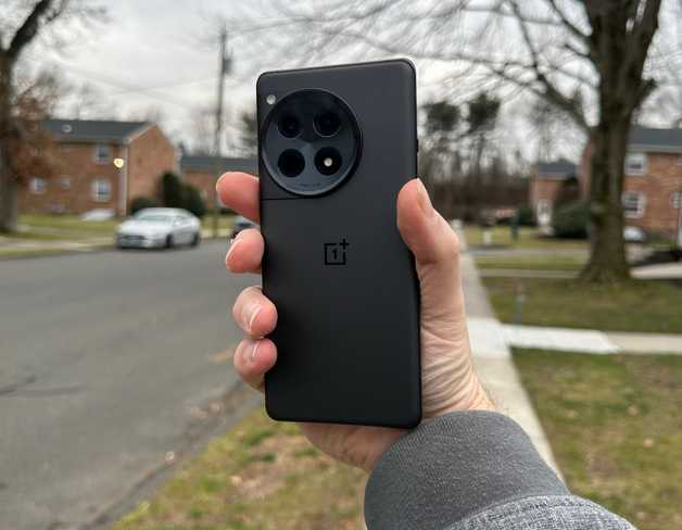 Holding the back of the OnePlus 12R outside.