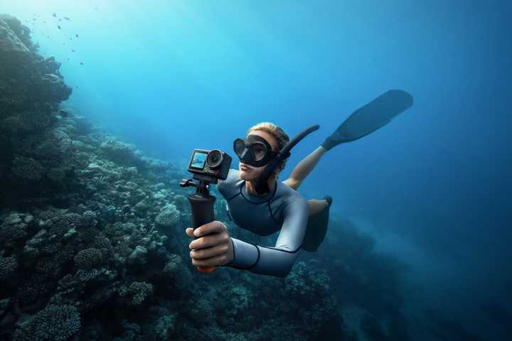 The DJI Osmo Action 5 Pro is held underwater