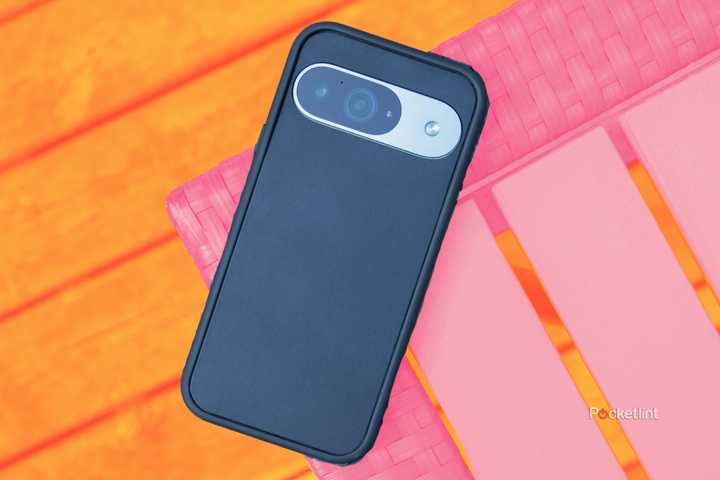 A Pixel 9 in a Dbrand grip case sitting on the edge of a table.