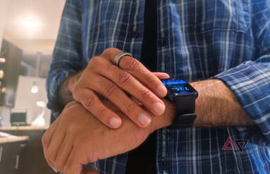 A person wearing a RingConn Smart Ring and Oppo Watch, checking the time
