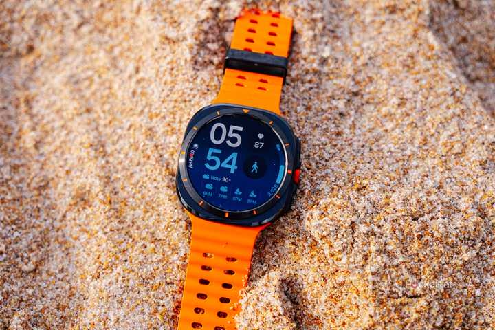 The Samsung Galaxy Watch Ultra sits in sand. 