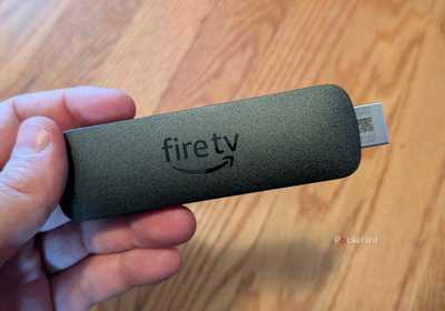 A person holding the Amazon Fire TV Stick 4K Select.