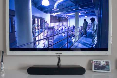 A black Sonos Ray sound bar under a white television.