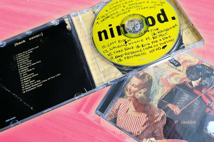 Two Green Day CD cases, one open and resting on top of the other.