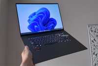 Windows 11 laptop being held up in the air.