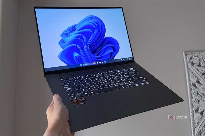 A Windows 11 laptop being held up in the air.