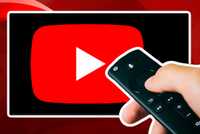 Person holding TV remote in front of TV with YouTube app on it.